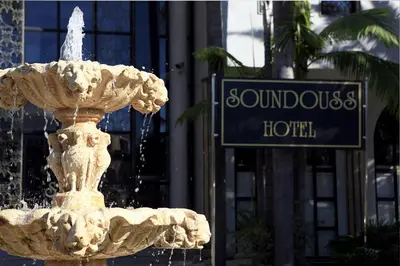 a fountain in front of a building with a street sign at Soundouss Hotel in Rabat
