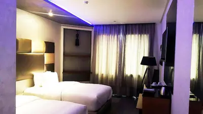 a hotel room with two beds and a window at The Seven Hotel in Casablanca