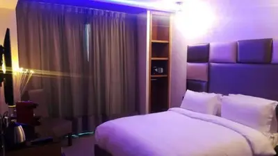 a bedroom with a white bed and a purple light at The Seven Hotel in Casablanca
