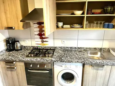 a small kitchen with a washing machine and a sink at Short Stay Apartment aéroport casablanca in Nouaseur
