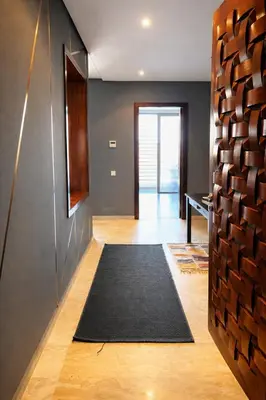 a hallway with a black rug and a black wall at Short Stay Apartment aéroport casablanca in Nouaseur