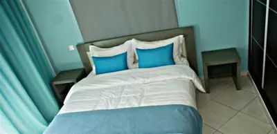 a bed with blue and white pillows in a bedroom at Zitouna Rooms in Casablanca