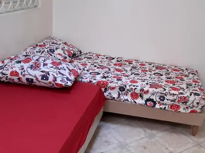 a small bed in a room with a red table at Zitouna Rooms in Casablanca