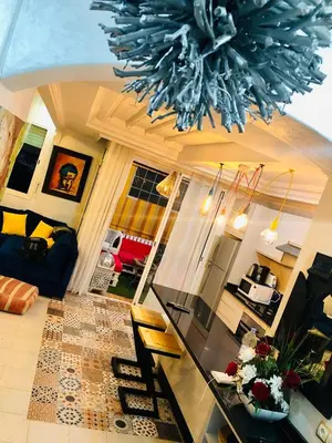 a living room with a glass table and a chandelier at Un Havre de paix a Ricoflores in Mohammedia