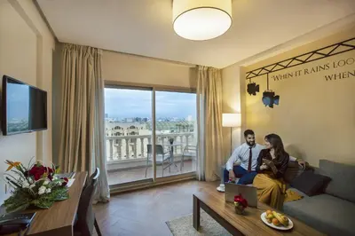 a man and woman sitting on a couch in a living room at Melliber Appart Hotel in Casablanca