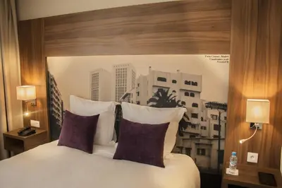 a bedroom with a large bed with two purple pillows at Melliber Appart Hotel in Casablanca