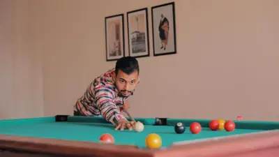 a man playing pool on a pool table at Melliber Appart Hotel in Casablanca