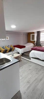a room with two beds and a sink in it at Studios Taha in Rabat