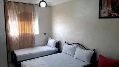 a room with two beds and a window with at Reem in Temara