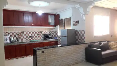 a kitchen with a counter and a couch in a room at Reem in Temara