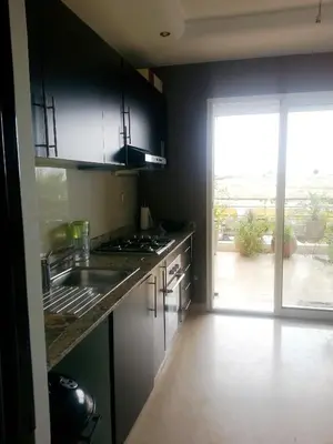 a kitchen with a sink and a door to a patio at Perle de Tamaris in Dar Bouazza