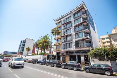a street with cars parked in front of a building at DownTown Hotel Maârif Casablanca By TSA in Casablanca