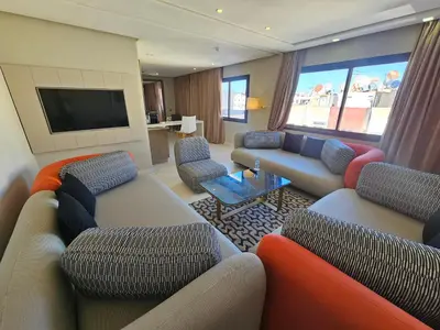 a living room with couches and a flat screen tv at DownTown Hotel Maârif Casablanca By TSA in Casablanca