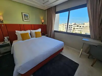a hotel room with a large bed and a window at DownTown Hotel Maârif Casablanca By TSA in Casablanca