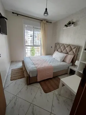 a bedroom with a large bed and a window at appartement plage Bouznika in Bouznika