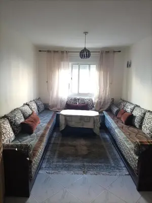 a living room with a couch and a table at appartement plage Bouznika in Bouznika