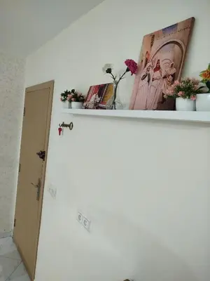 a white wall with a shelf with plants on it at appartement plage Bouznika in Bouznika