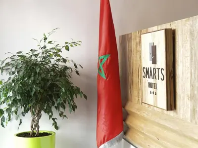 a plant in a pot next to a flag at Smarts Hotel Agdal Rabat in Rabat