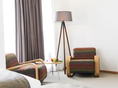a hotel room with a chair and a lamp at Smarts Hotel Agdal Rabat in Rabat