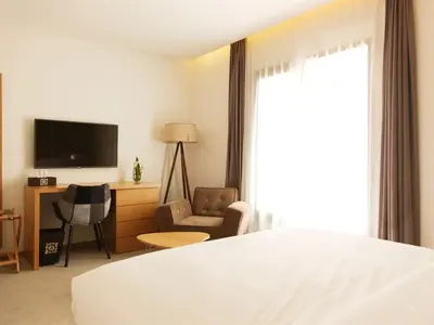 a hotel room with a bed and a chair and a television at Smarts Hotel Agdal Rabat in Rabat