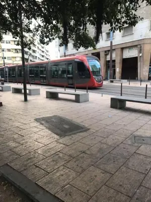 a red train is parked next to some benches at Casablanca centre ville in Casablanca