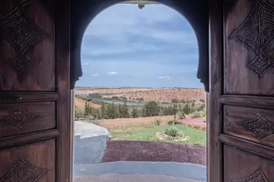 an open wooden door with a view of a field at Safa Boulaouane in Douar Annbirat