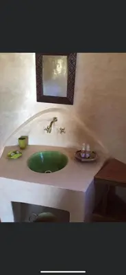 a bathroom with a green sink and a mirror at Safa Boulaouane in Douar Annbirat