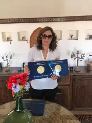a woman holding a box in a kitchen at Safa Boulaouane in Douar Annbirat