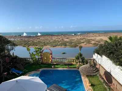 a swimming pool with a view of the beach at Aux Moules de Harhoura Rabat in El Harhoura