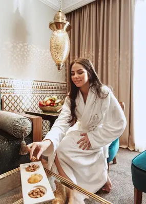 a woman sitting in a room with a tray of food at Le Casablanca Hotel in Casablanca