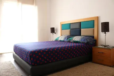 a bedroom with a bed with a blue and red blanket at Appartement ,Tram Parking and wifi gratui in Casablanca