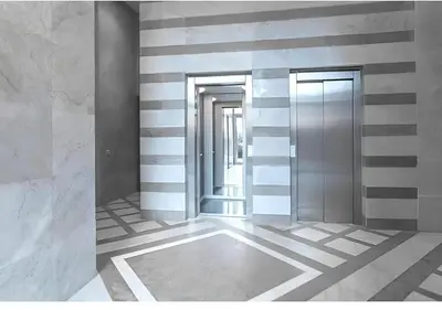 an empty lobby with two elevators and striped walls at Appartement ,Tram Parking and wifi gratui in Casablanca