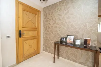 a room with a wooden door and a table with pictures at Luxe & sérénité près de l Aireport Mohamed 5, votre Havre de Paix in Nouaseur