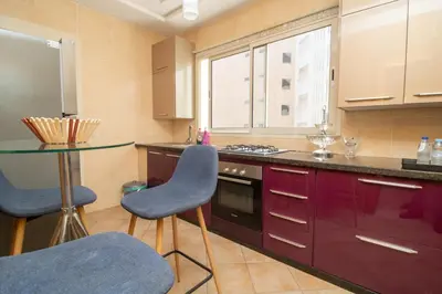 a kitchen with purple cabinets and a table and chairs at Luxe & sérénité près de l Aireport Mohamed 5, votre Havre de Paix in Nouaseur