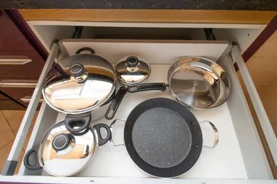 a set of pots and pans in a drawer at Luxe & sérénité près de l Aireport Mohamed 5, votre Havre de Paix in Nouaseur