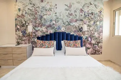 a bedroom with a large bed with a floral wallpaper at Luxe & sérénité près de l Aireport Mohamed 5, votre Havre de Paix in Nouaseur