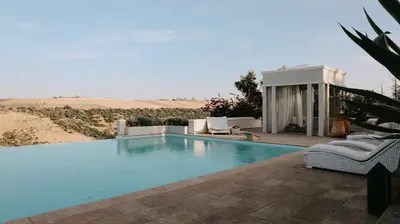 a swimming pool with two lounge chairs and aermottermott at Villa Soraya Lodge & Spa in Rabat