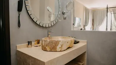 a bathroom with a large stone sink and a mirror at Villa Soraya Lodge & Spa in Rabat