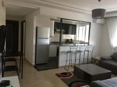 a kitchen and living room with a refrigerator and a couch at DaliMAR in Bouznika