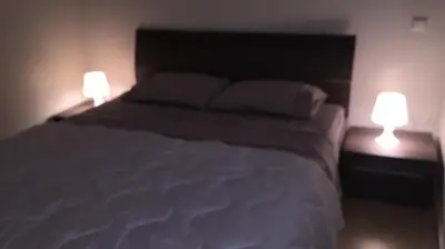 a bedroom with a bed with two lamps on it at DaliMAR in Bouznika