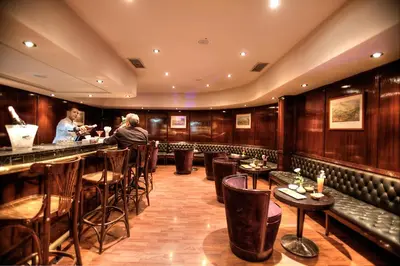 a bar with a woman standing at a counter at Casablanca Le Lido Thalasso & Spa (ex Riad Salam) in Casablanca