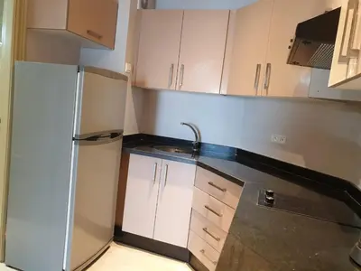 a kitchen with white cabinets and a refrigerator at Residence Davos Rabat in Rabat