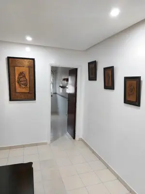 a room with a white wall with paintings on it at Apartment in the city center, 2 minutes walk from the tram in Rabat