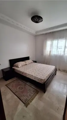 a bedroom with a bed in the corner of a room at Agdal Two-Bedroom Apartment 2 Minutes from Agdal Train Station in Rabat