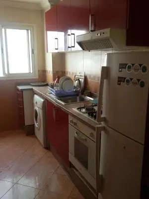 a kitchen with a stove and a sink and a refrigerator at Agdal Two-Bedroom Apartment 2 Minutes from Agdal Train Station in Rabat