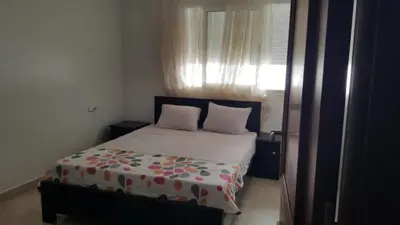 a bedroom with a bed with two pillows and a window at Agdal Two-Bedroom Apartment 2 Minutes from Agdal Train Station in Rabat