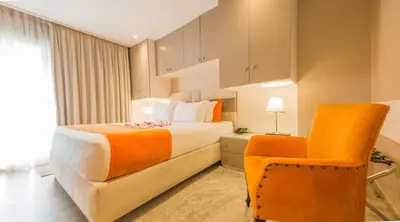 a hotel room with a bed and a chair at RENT-INN Suites Hotel in Rabat