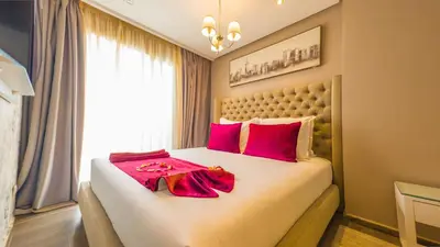 a bedroom with a large bed with red pillows at RENT-INN Suites Hotel in Rabat