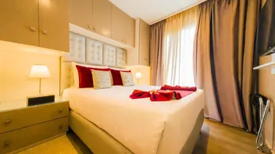 a bedroom with a large bed with red pillows at RENT-INN Suites Hotel in Rabat