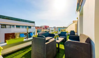 a balcony with chairs and a table on a building at RENT-INN Suites Hotel in Rabat